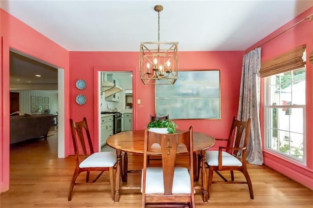 dining room with light hardwood / wood-style floors and an inviting chandelier