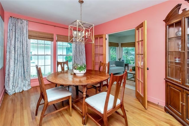 dining area featuring a wealth of natural light, light hardwood / wood-style flooring, a chandelier, and french doors