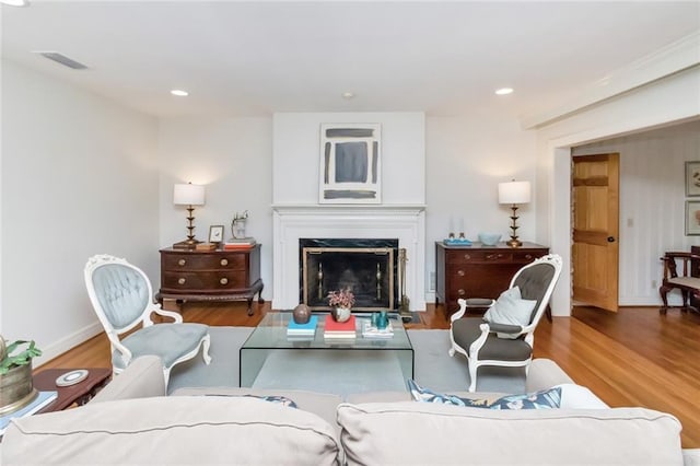 living room featuring hardwood / wood-style flooring and a high end fireplace