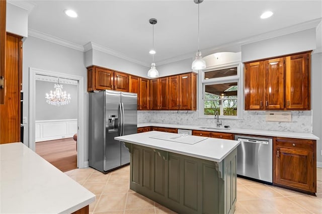 kitchen with stainless steel appliances, a center island, a notable chandelier, decorative light fixtures, and sink