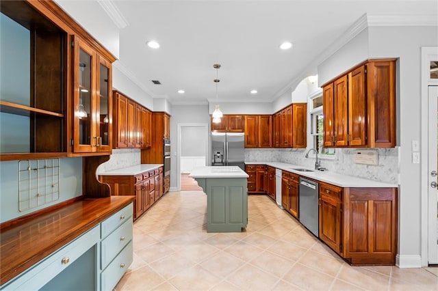 kitchen featuring appliances with stainless steel finishes, a kitchen island, decorative light fixtures, sink, and ornamental molding