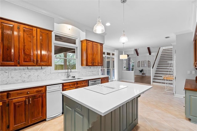 kitchen with sink, pendant lighting, dishwasher, and a kitchen island