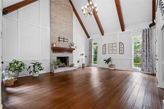 unfurnished living room featuring dark hardwood / wood-style flooring, a brick fireplace, beamed ceiling, a notable chandelier, and high vaulted ceiling