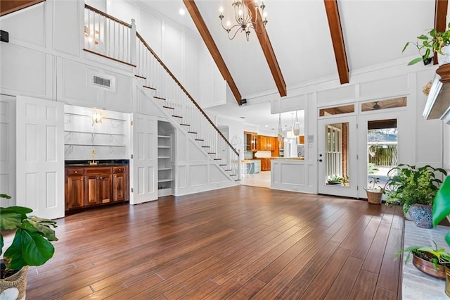 living room featuring high vaulted ceiling, wood-type flooring, beam ceiling, and a chandelier