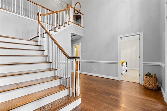 stairway featuring a high ceiling and hardwood / wood-style flooring