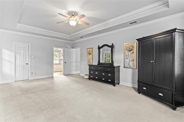 bedroom with light carpet, ensuite bathroom, ceiling fan, a tray ceiling, and ornamental molding