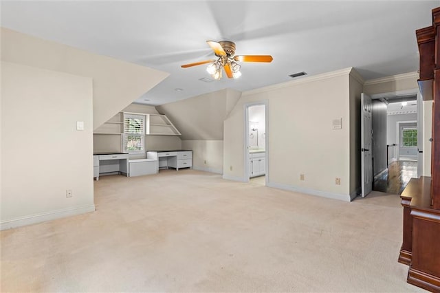 bonus room with light carpet, ceiling fan, built in desk, and lofted ceiling