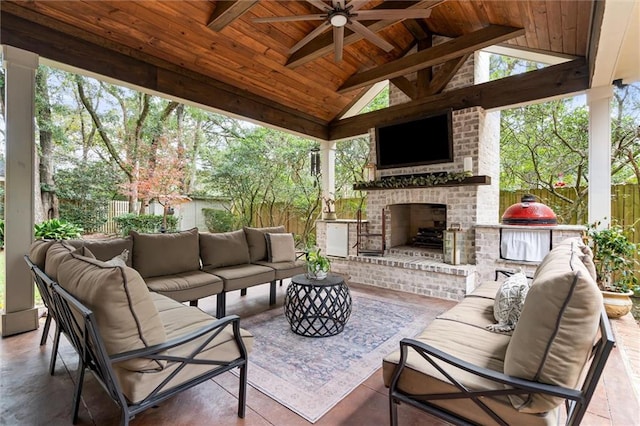 view of patio with ceiling fan, a gazebo, and an outdoor living space with a fireplace