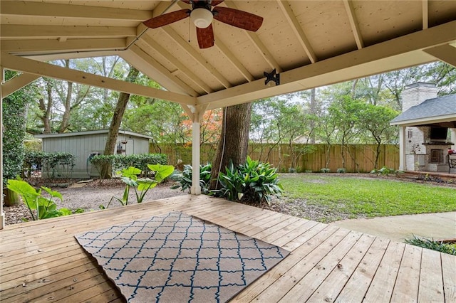 wooden terrace with ceiling fan and an outdoor structure