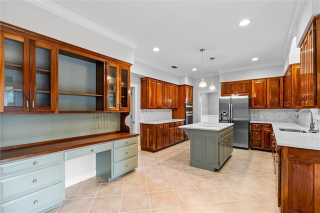 kitchen with pendant lighting, a center island, stainless steel appliances, sink, and ornamental molding