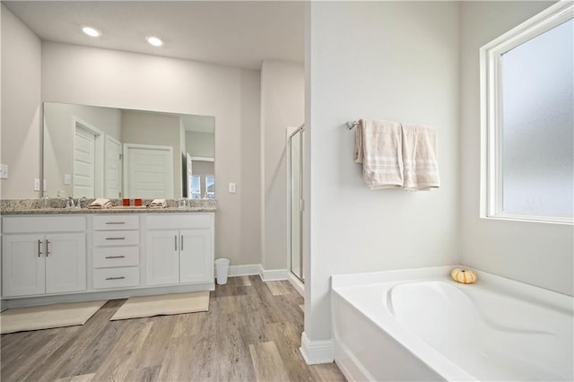 bathroom with vanity, wood-type flooring, and independent shower and bath