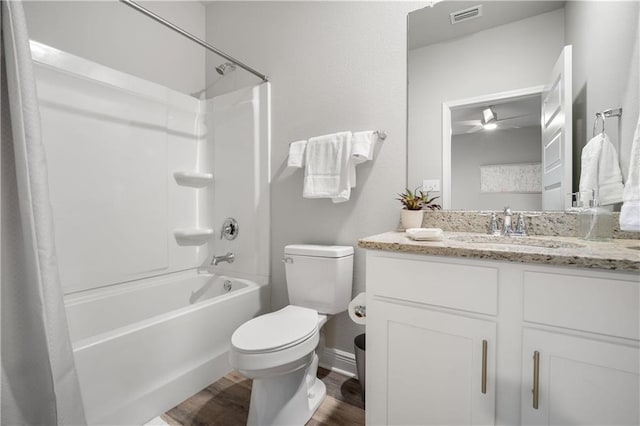 full bathroom with ceiling fan, shower / bathtub combination with curtain, wood-type flooring, toilet, and vanity