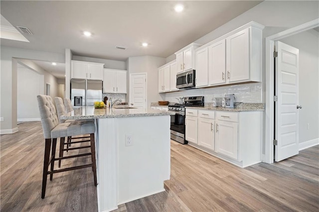 kitchen featuring sink, white cabinetry, an island with sink, and appliances with stainless steel finishes