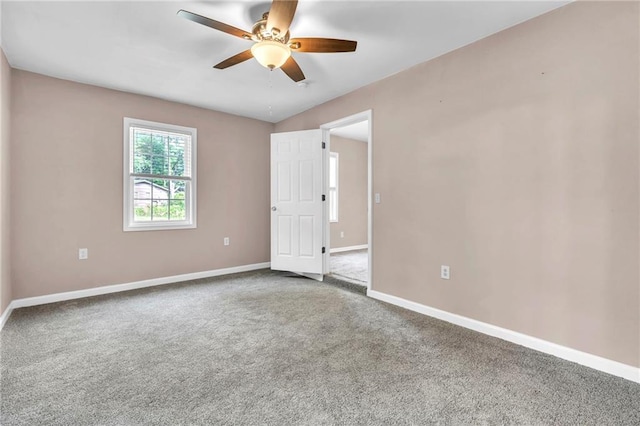 empty room featuring carpet flooring, baseboards, and ceiling fan