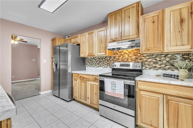 kitchen featuring stainless steel appliances, light brown cabinets, and under cabinet range hood