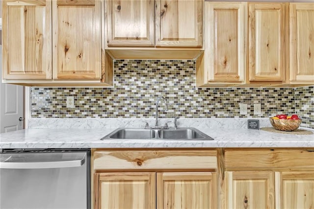 kitchen with decorative backsplash, stainless steel dishwasher, light brown cabinetry, and a sink