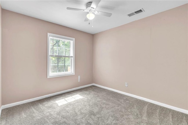 spare room featuring baseboards, a ceiling fan, visible vents, and carpet floors