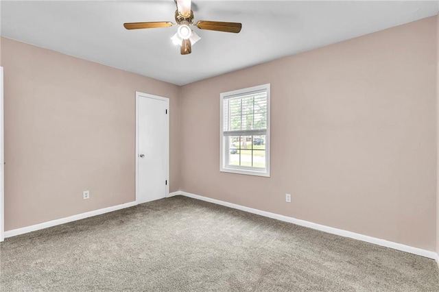 carpeted empty room featuring baseboards and ceiling fan