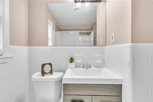 bathroom with wainscoting, vanity, tile walls, toilet, and a shower with shower curtain