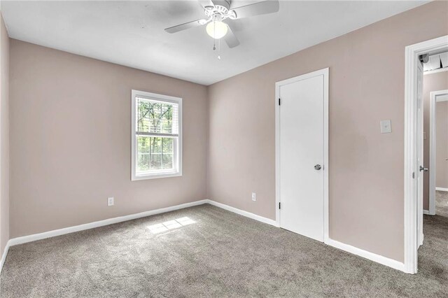 unfurnished room featuring a ceiling fan, baseboards, and carpet