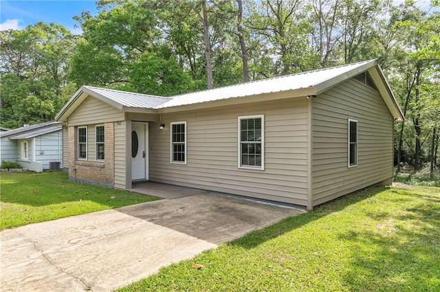 ranch-style house with a patio, a front lawn, and metal roof