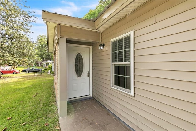 entrance to property with a lawn