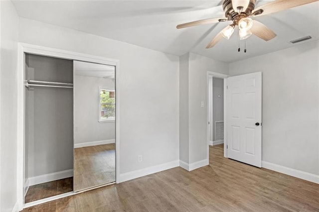 unfurnished bedroom featuring ceiling fan, hardwood / wood-style flooring, and a closet