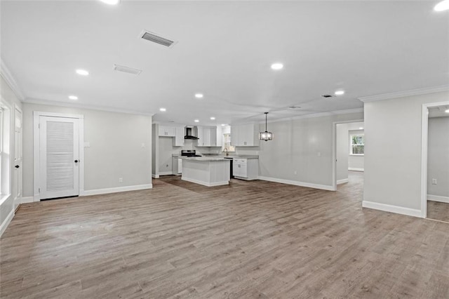 unfurnished living room featuring hardwood / wood-style floors and crown molding