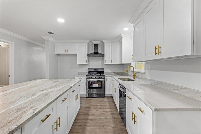 kitchen featuring stainless steel range with gas stovetop, crown molding, wall chimney exhaust hood, wood-type flooring, and white cabinetry