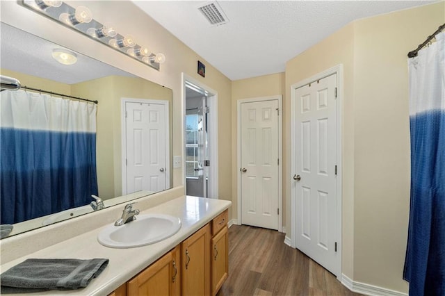 bathroom featuring vanity, a textured ceiling, and wood-type flooring