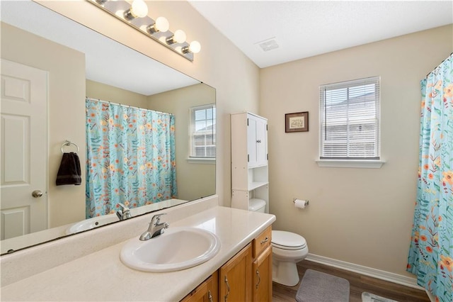 bathroom with vanity, toilet, and wood-type flooring