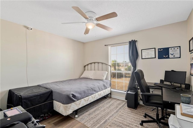 bedroom featuring a textured ceiling, wood-type flooring, and ceiling fan