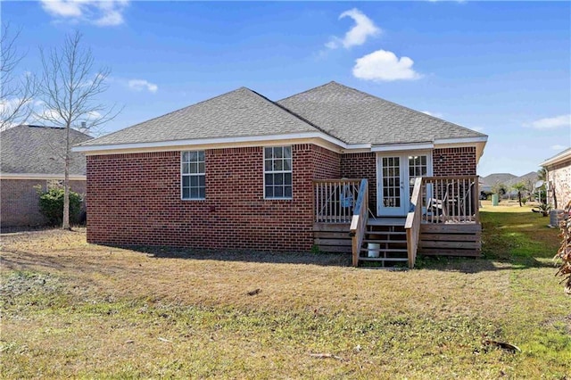 back of house featuring a deck and a lawn