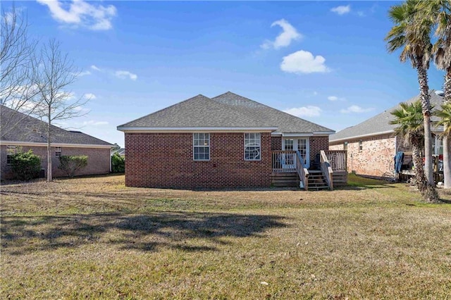 rear view of property with a wooden deck and a yard