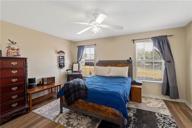 bedroom featuring hardwood / wood-style floors, multiple windows, and ceiling fan