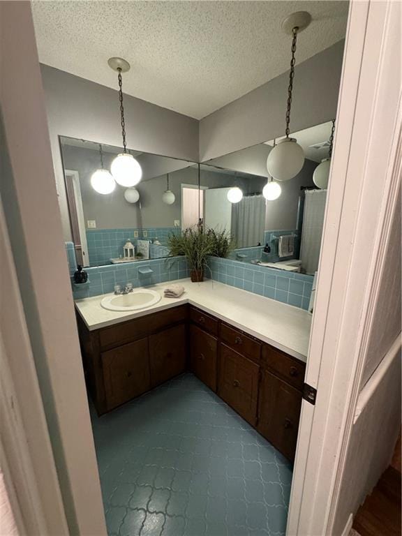 bathroom featuring vanity, backsplash, and a textured ceiling