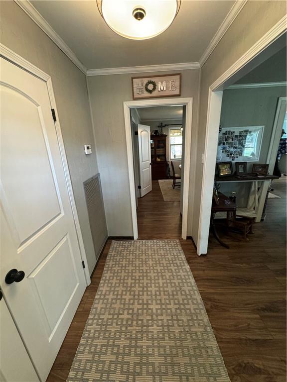 hallway with ornamental molding and dark hardwood / wood-style floors