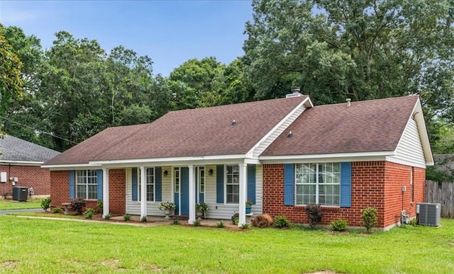 single story home featuring a front yard, covered porch, and central air condition unit