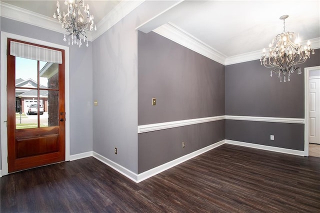 foyer with an inviting chandelier, ornamental molding, baseboards, and wood finished floors
