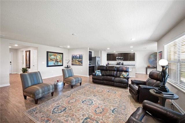 8320 Ogilvy Ct, Daphne, AL 36526 - living room featuring recessed lighting, baseboards, light wood-style flooring, and a textured ceiling