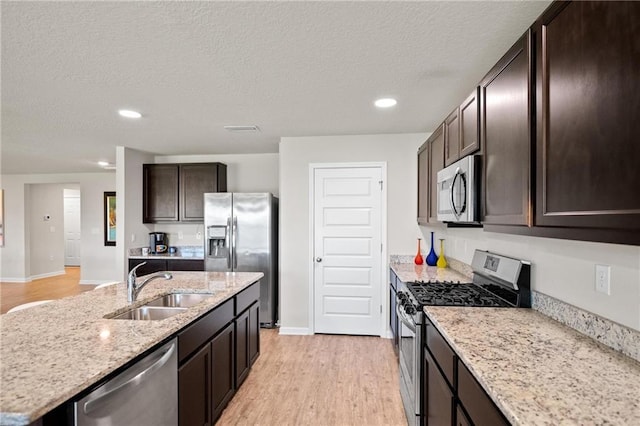 8320 Ogilvy Ct, Daphne, AL 36526 - kitchen with a sink, appliances with stainless steel finishes, dark brown cabinetry, and light wood-style flooring