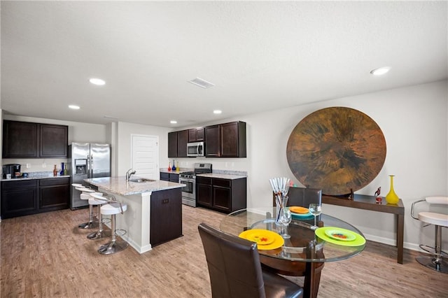 8320 Ogilvy Ct, Daphne, AL 36526 - kitchen featuring a kitchen bar, recessed lighting, a sink, light wood finished floors, and appliances with stainless steel finishes
