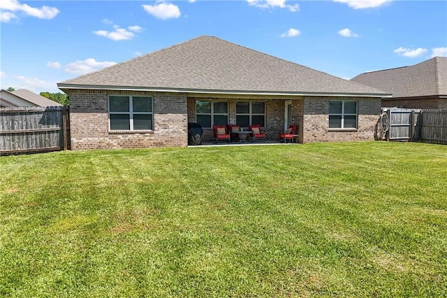 8320 Ogilvy Ct, Daphne, AL 36526 - back of house featuring a fenced backyard, roof with shingles, brick siding, a patio area, and a yard