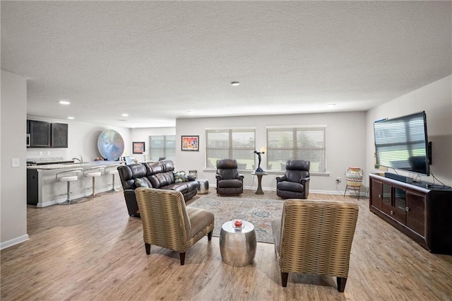 8320 Ogilvy Ct, Daphne, AL 36526 - living area featuring light wood-type flooring, recessed lighting, a textured ceiling, and a healthy amount of sunlight