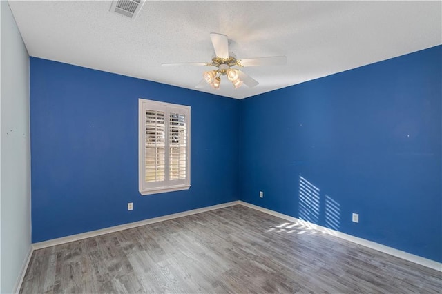 spare room with ceiling fan, hardwood / wood-style floors, and a textured ceiling