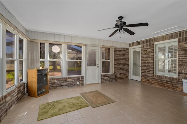 unfurnished sunroom with ceiling fan and plenty of natural light