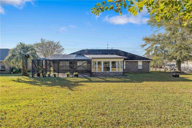 back of house featuring a lanai and a yard