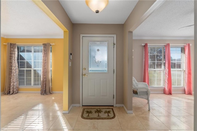 tiled foyer with a textured ceiling and ornamental molding