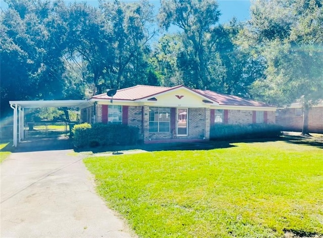 ranch-style home featuring a front yard, brick siding, driveway, and an attached carport