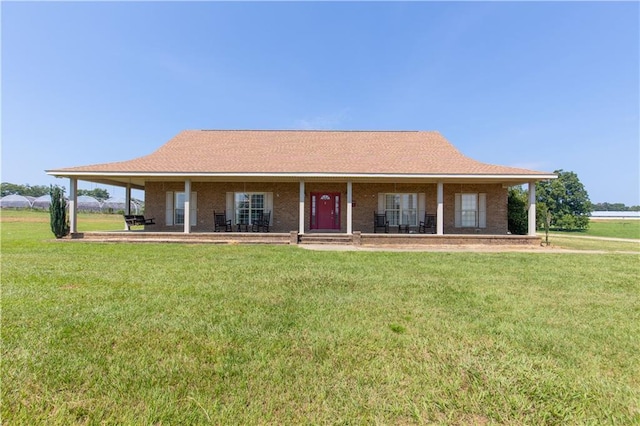 farmhouse featuring a porch, brick siding, and a front lawn